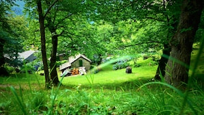 A rustic stone house surrounded by lush greenery and trees. - Hotel Santoli (Alto Reno Terme)