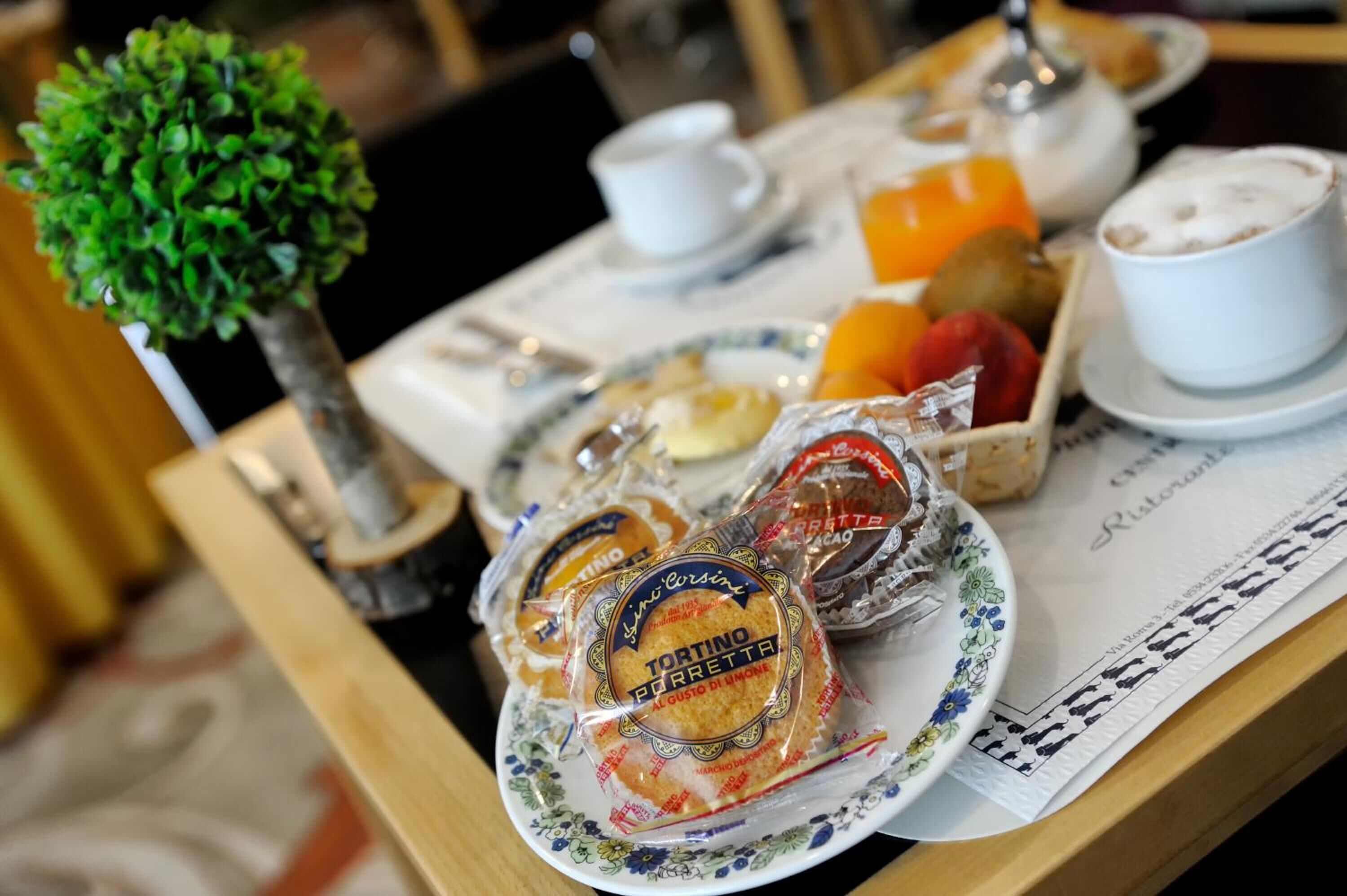 A breakfast tray with pastries, a small tree, and a cup of coffee.