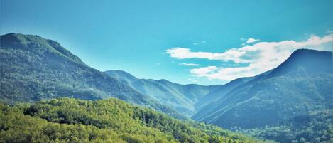 A mountainous landscape with lush green valleys and a clear sky.