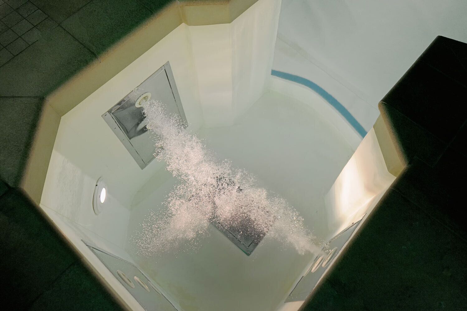 Una vasca da bagno con doccetta e scarico a vista.