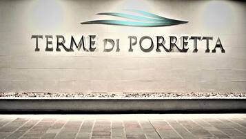 A sign with the text "TERME DI PORREtta" and a stylized wave design above it.
