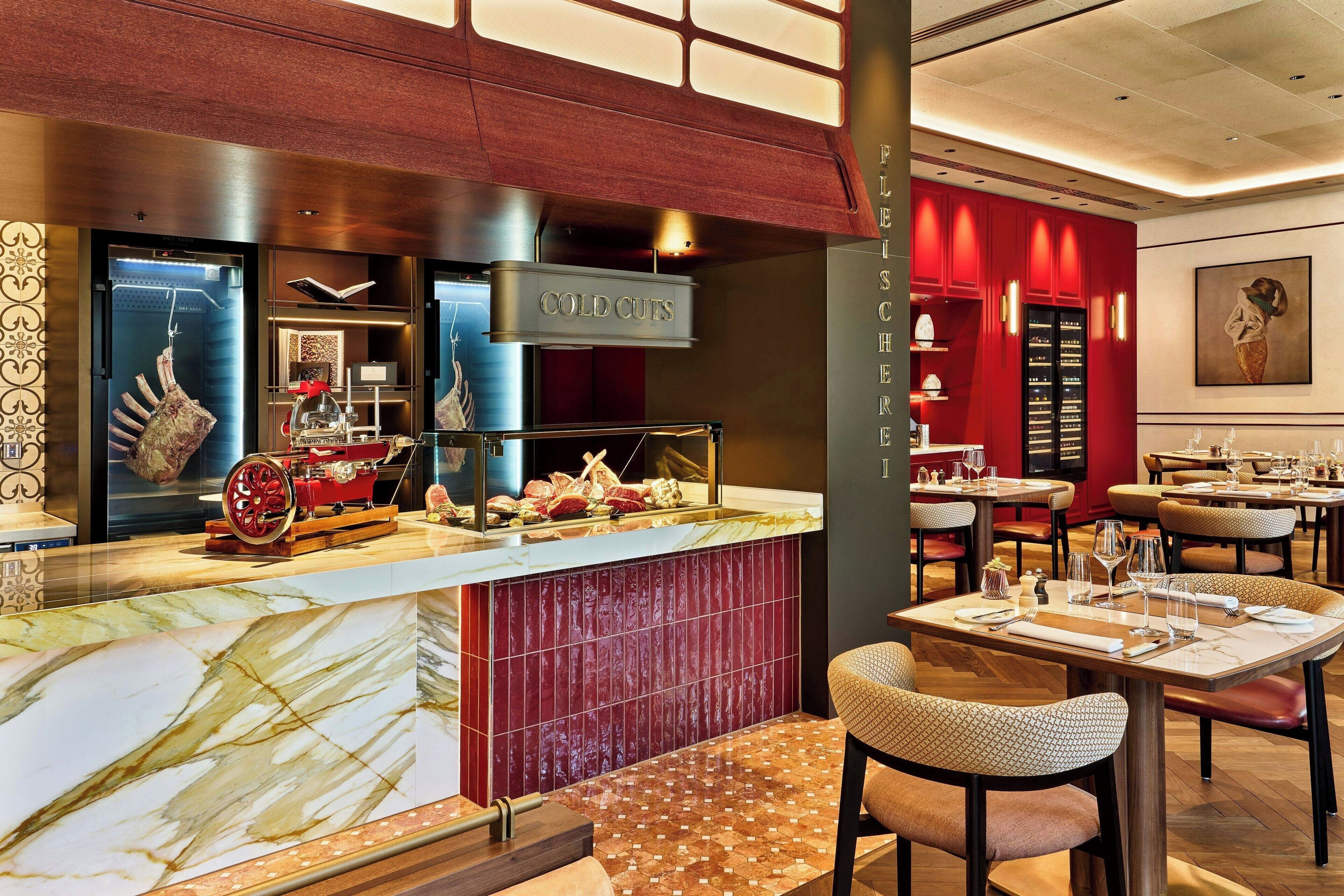 A restaurant with a marble countertop, red tiled backsplash, and a sign reading "COLD CUTS".