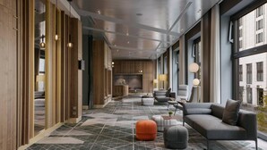 A modern hotel lobby with a geometric patterned floor, a sofa set, and a large window offering a view of the city. - Berlin Marriott Hotel (Berlin)