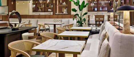 A modern interior with wooden accents, marble tables, and wicker chairs.