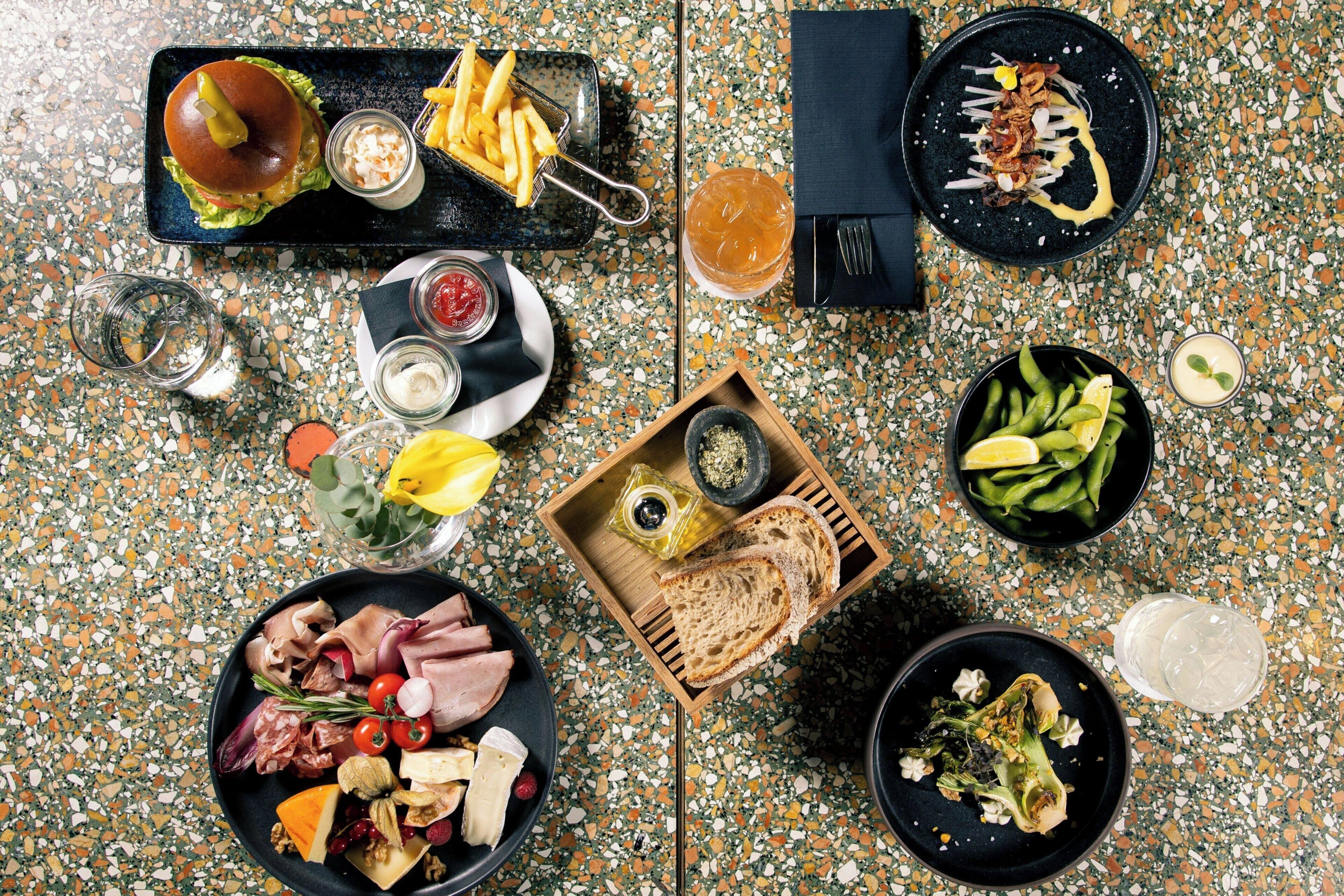 A top-down view of a dining table with various food items and drinks.