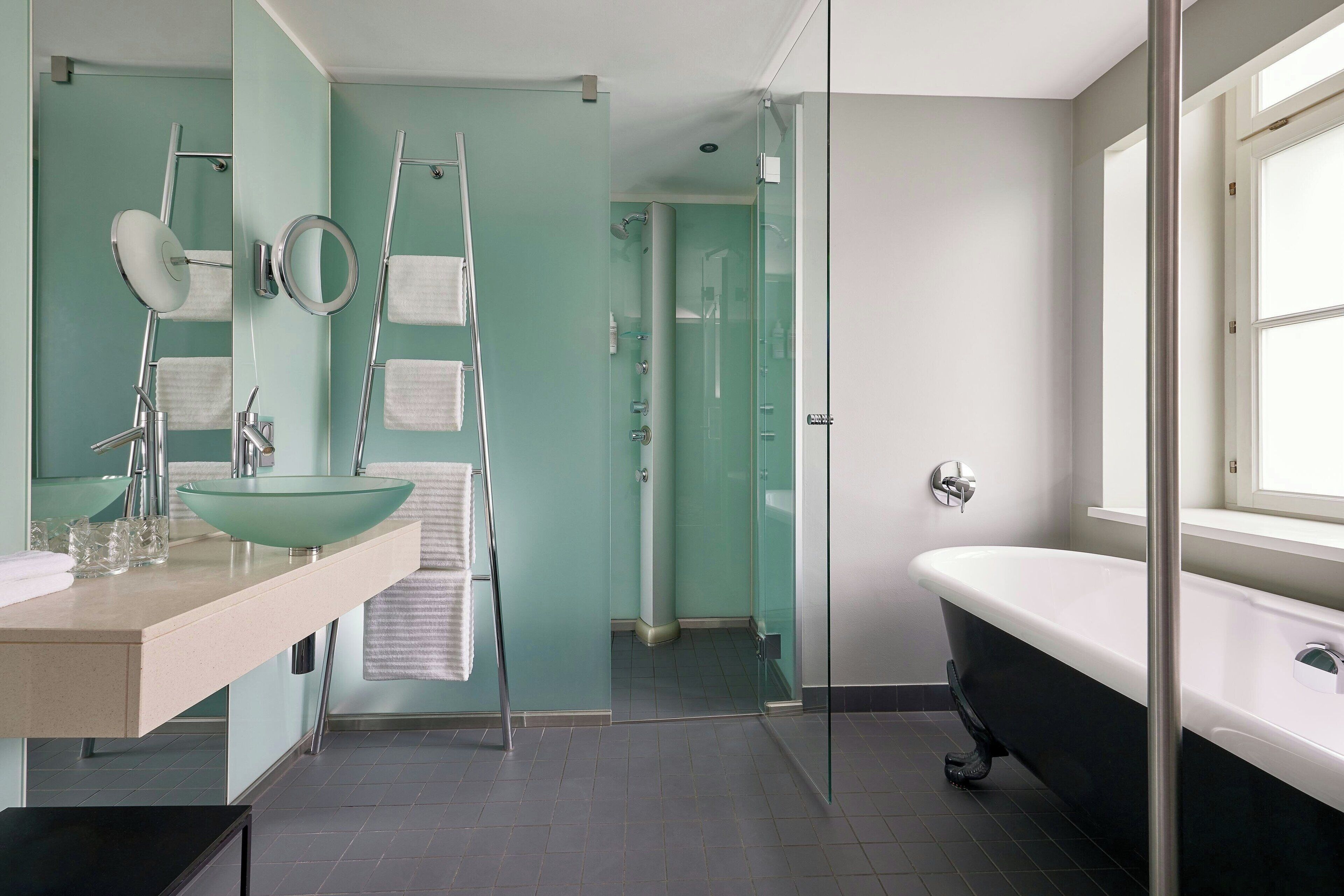 Une salle de bain dotée d’une douche à parois de verre, d’une baignoire sur pieds et d’un meuble-lavabo avec un vasque.