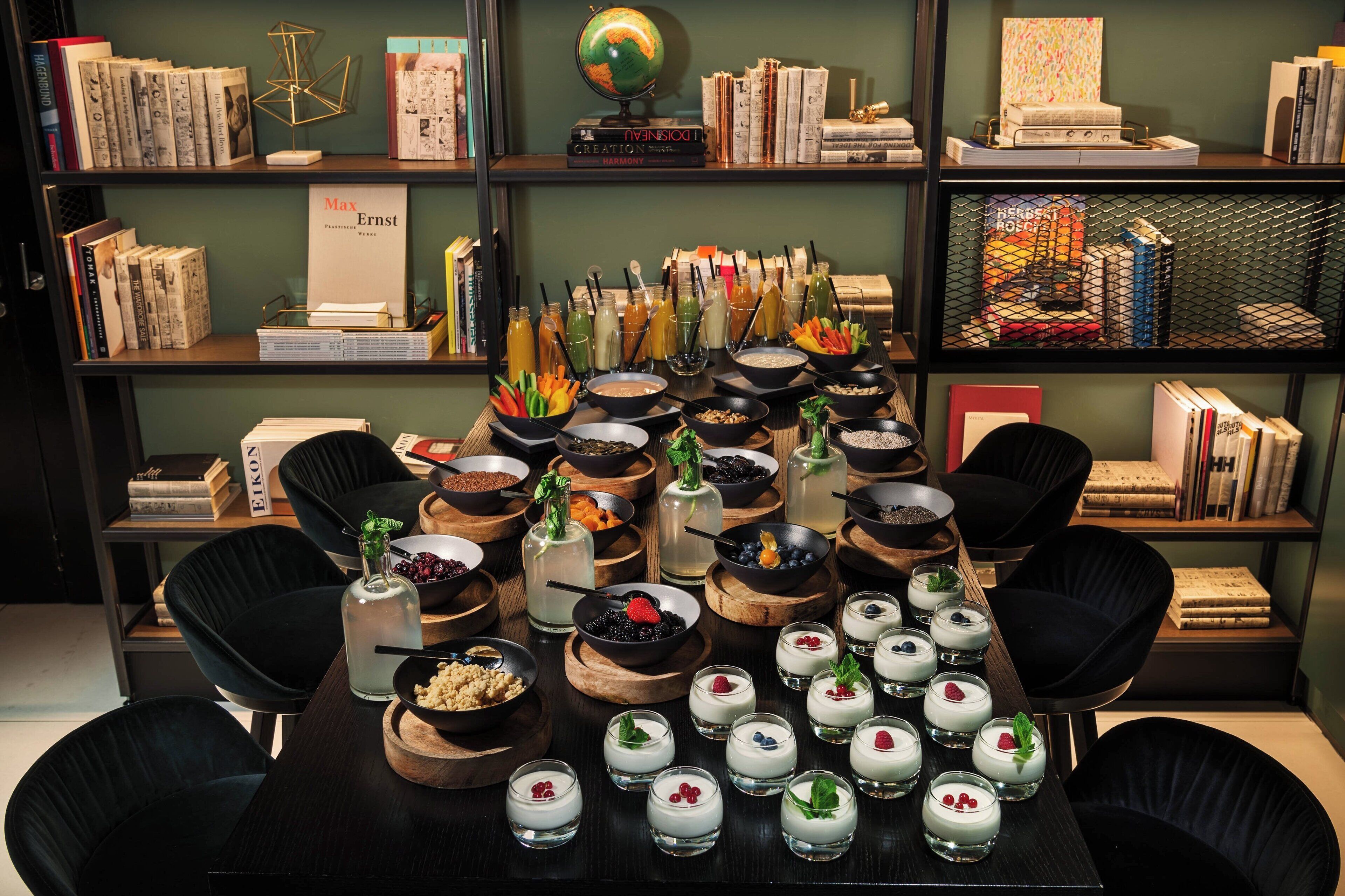 A table set with various food items and a bookshelf in the background.
