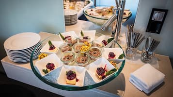 Buffet com diversos doces e uma vitrine de vidro.