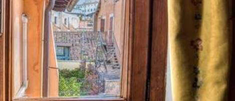A window with a view of a building with a staircase and a balcony.