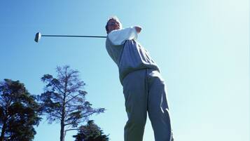 A person playing golf on a clear day.