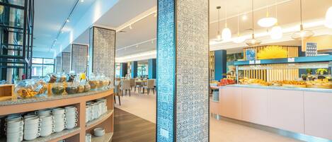 A modern hotel lobby with a central column, a buffet area, and seating arrangements.