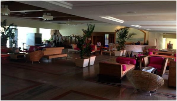 A spacious lobby with multiple seating areas, including sofas and chairs, and several potted plants. - The Zuri White Sands, Goa Resort & Casino (Varca)