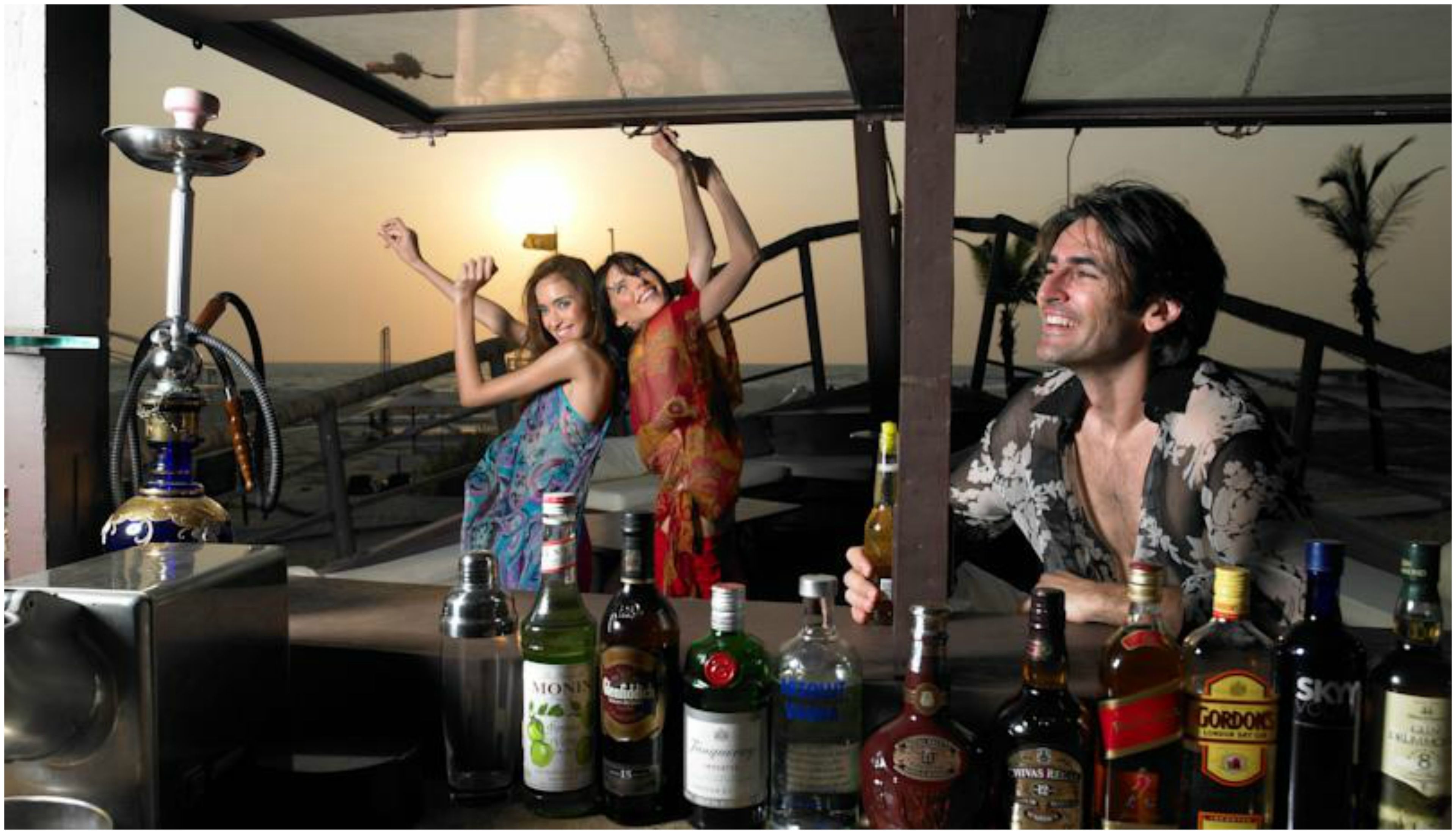 A bar area with a variety of bottles and a hookah.