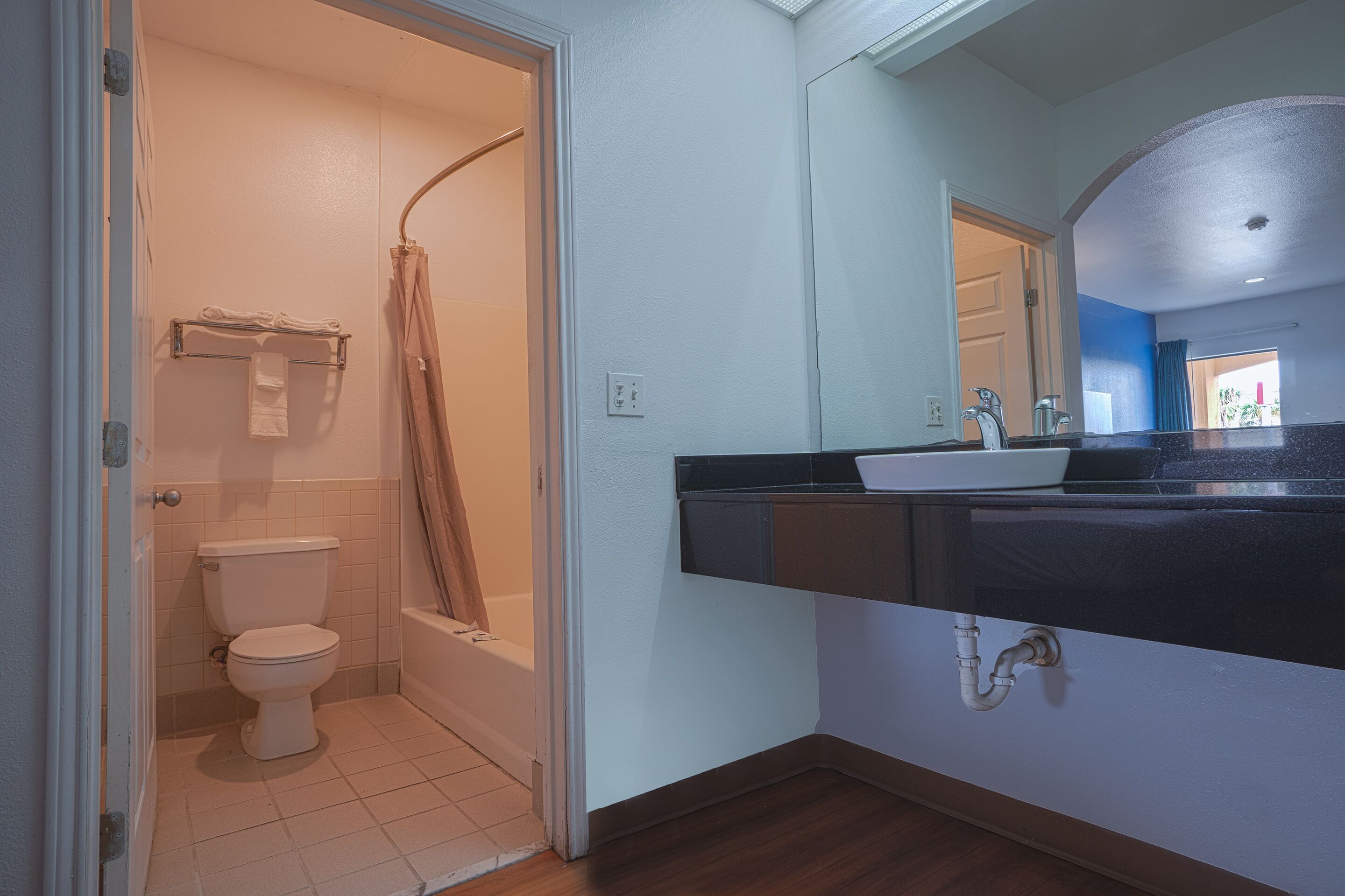 A bathroom with a toilet, shower, and sink.
