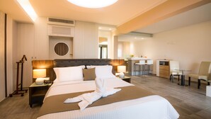 Una habitación de hotel con una cama grande, mesitas de noche con lámparas, un escritorio y una silla.