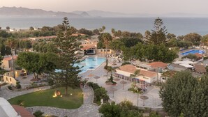 Un resort con piscina, mobiliario exterior y vistas al mar.
