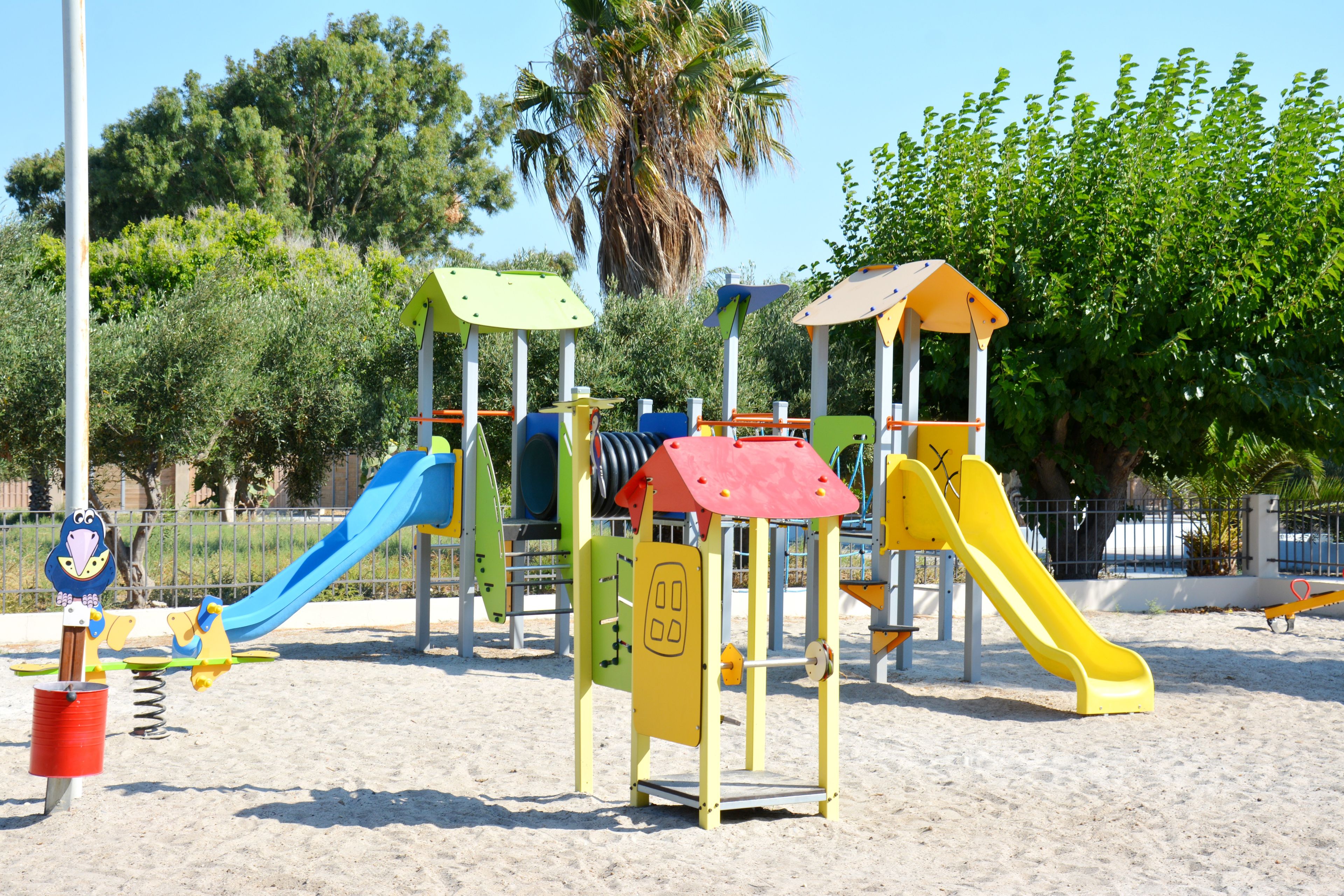 Ein Spielplatz mit verschiedenen Spielgeräten, darunter Rutschen und Kletterbereiche.