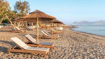 On the beach, sun-loungers, beach umbrellas, beach bar