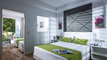 A modern hotel room with a large bed, a green accent wall, and a view of the outdoors.