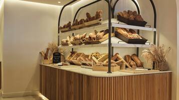 A bakery display with various breads and pastries.