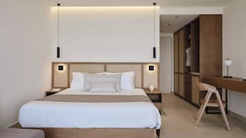 A modern bedroom with a large bed, bedside tables, a desk, and a chair.