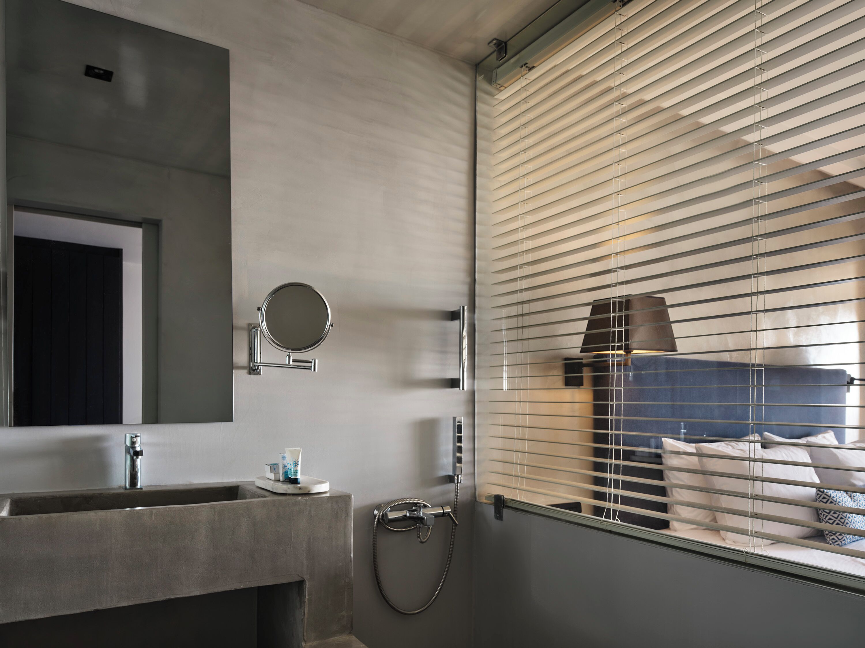 A modern bathroom with a large mirror, a sink, and a shower.