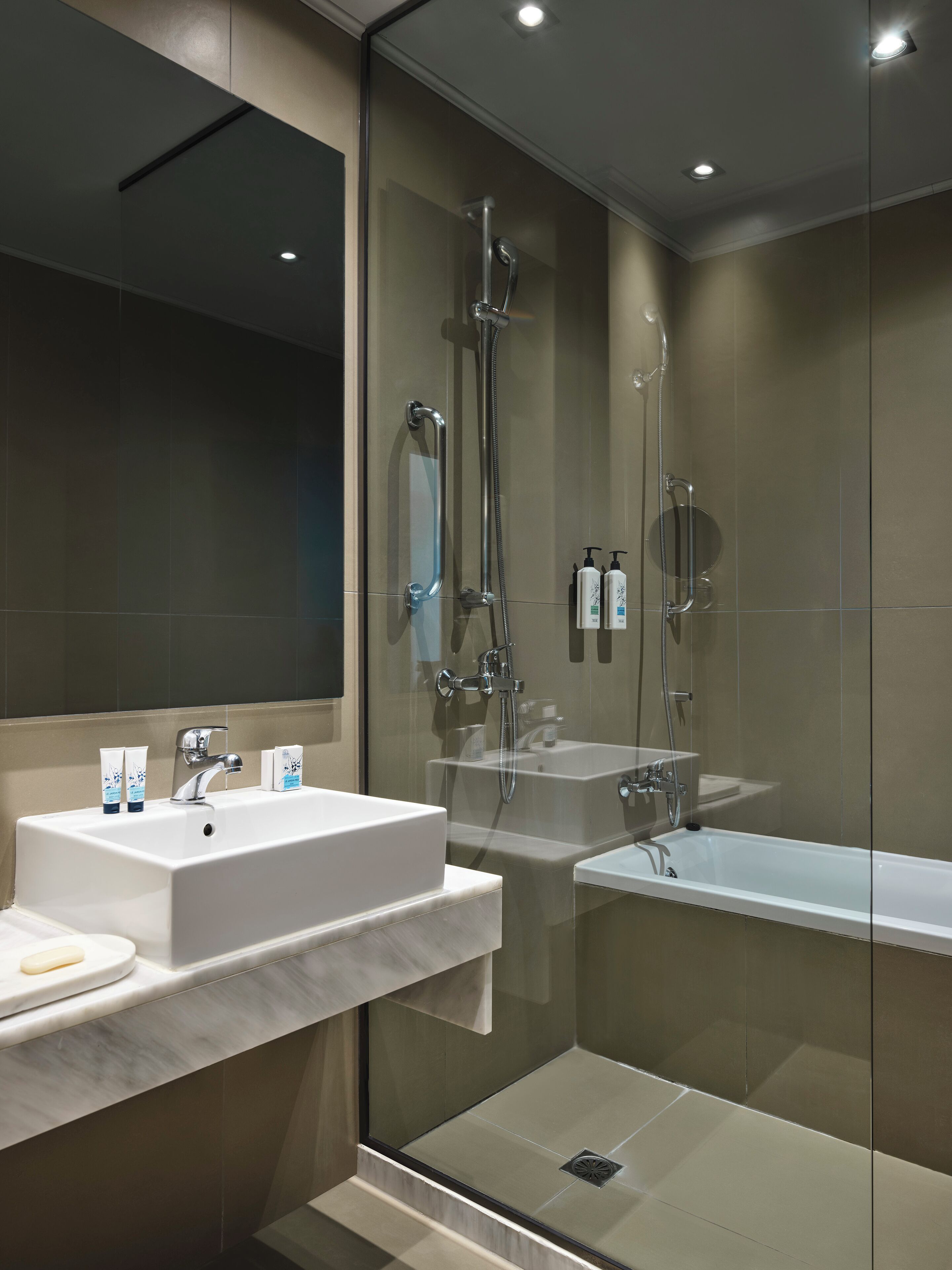A modern bathroom with a glass-enclosed shower, a freestanding bathtub, and a vanity with a mirror.