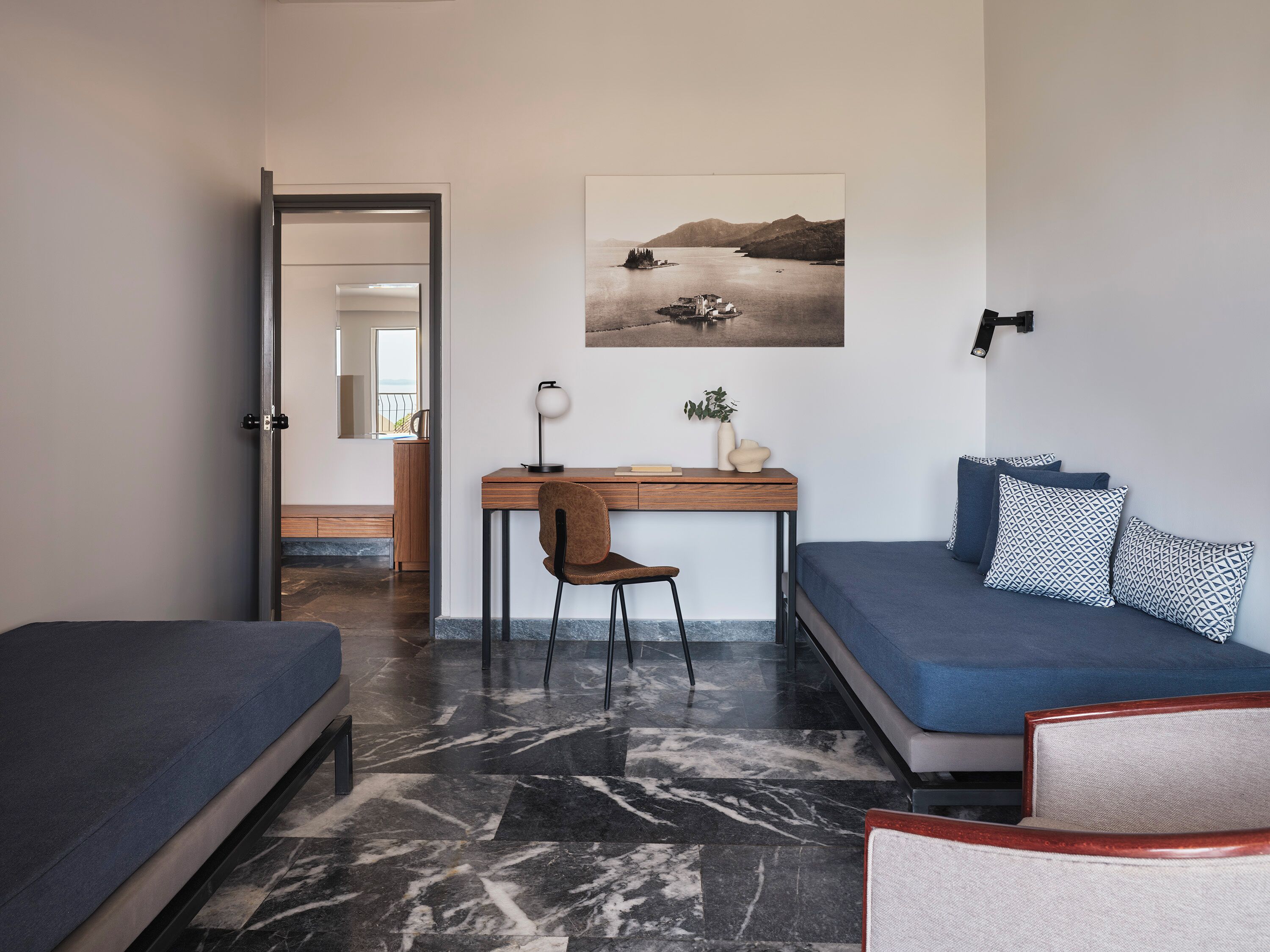 A modern room with a bed, a desk, and a sofa.