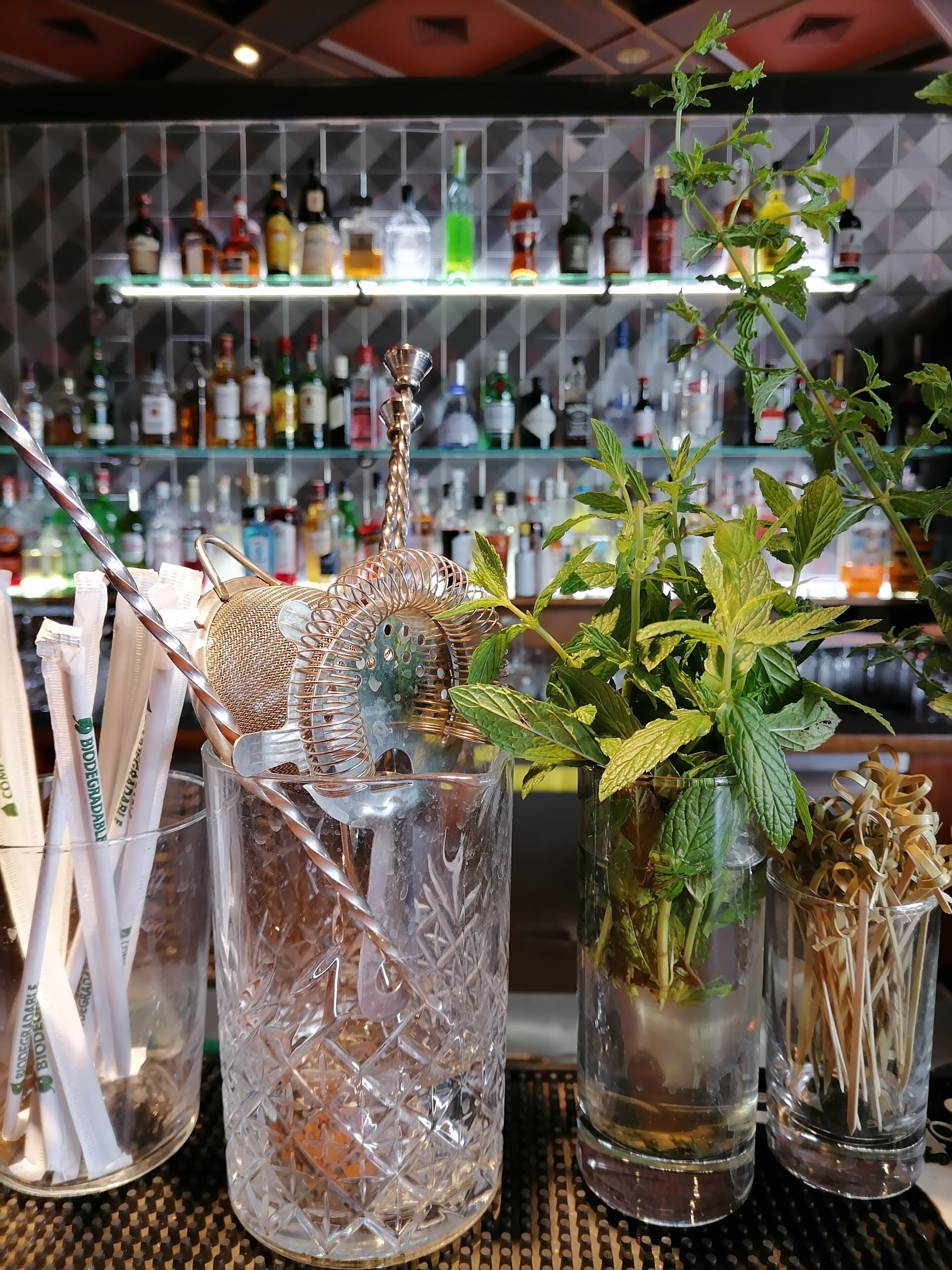 A bar area with a variety of bottles and a decorative metal piece.
