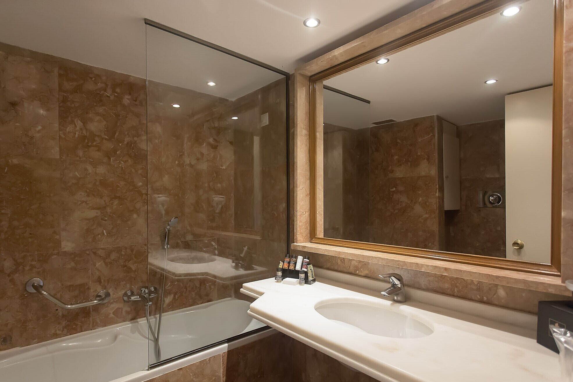 Een moderne badkamer met een douchecabine van glas, een wastafelmeubel en een grote spiegel.