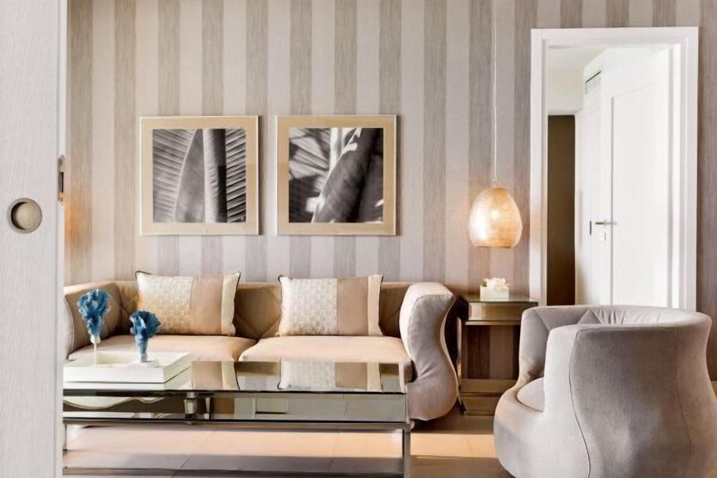 A modern living room with a sofa, a glass coffee table, and a lamp.
