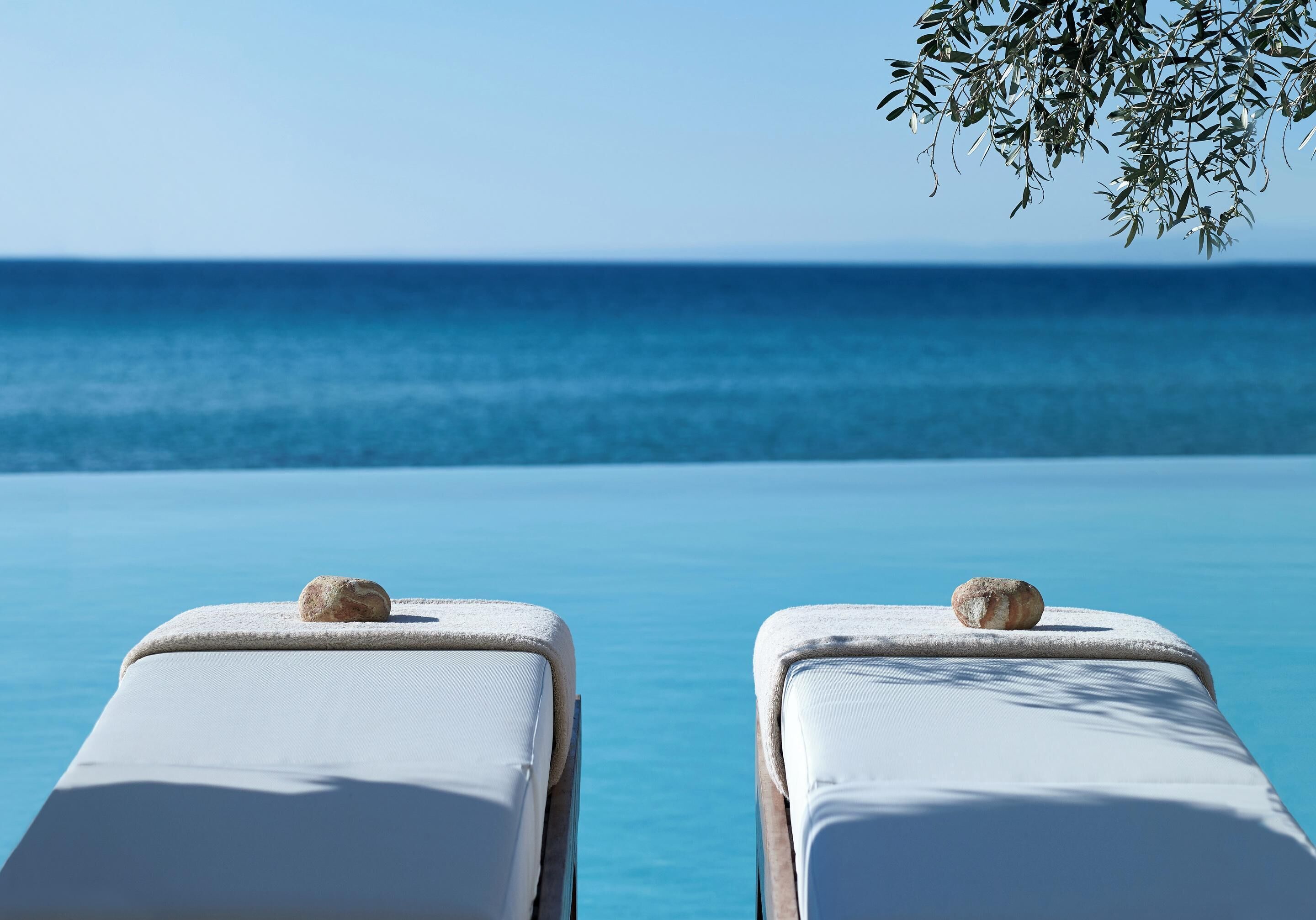 Two sun loungers with a view of the ocean.