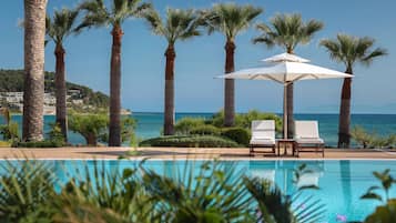 Een buitenzwembad, een infinity pool, parasols voor strand/zwembad
