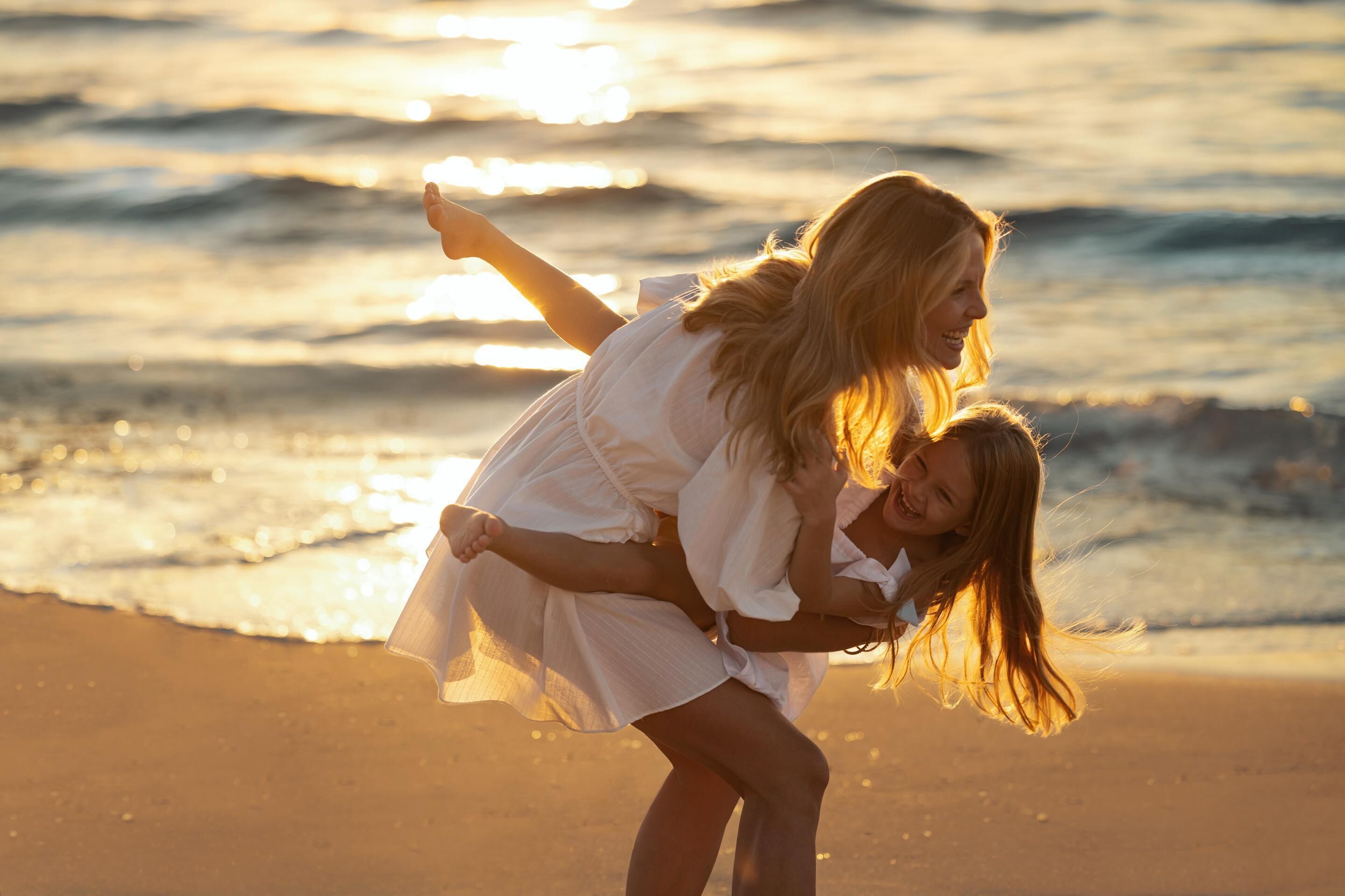A beach scene with a person carrying another on their back.