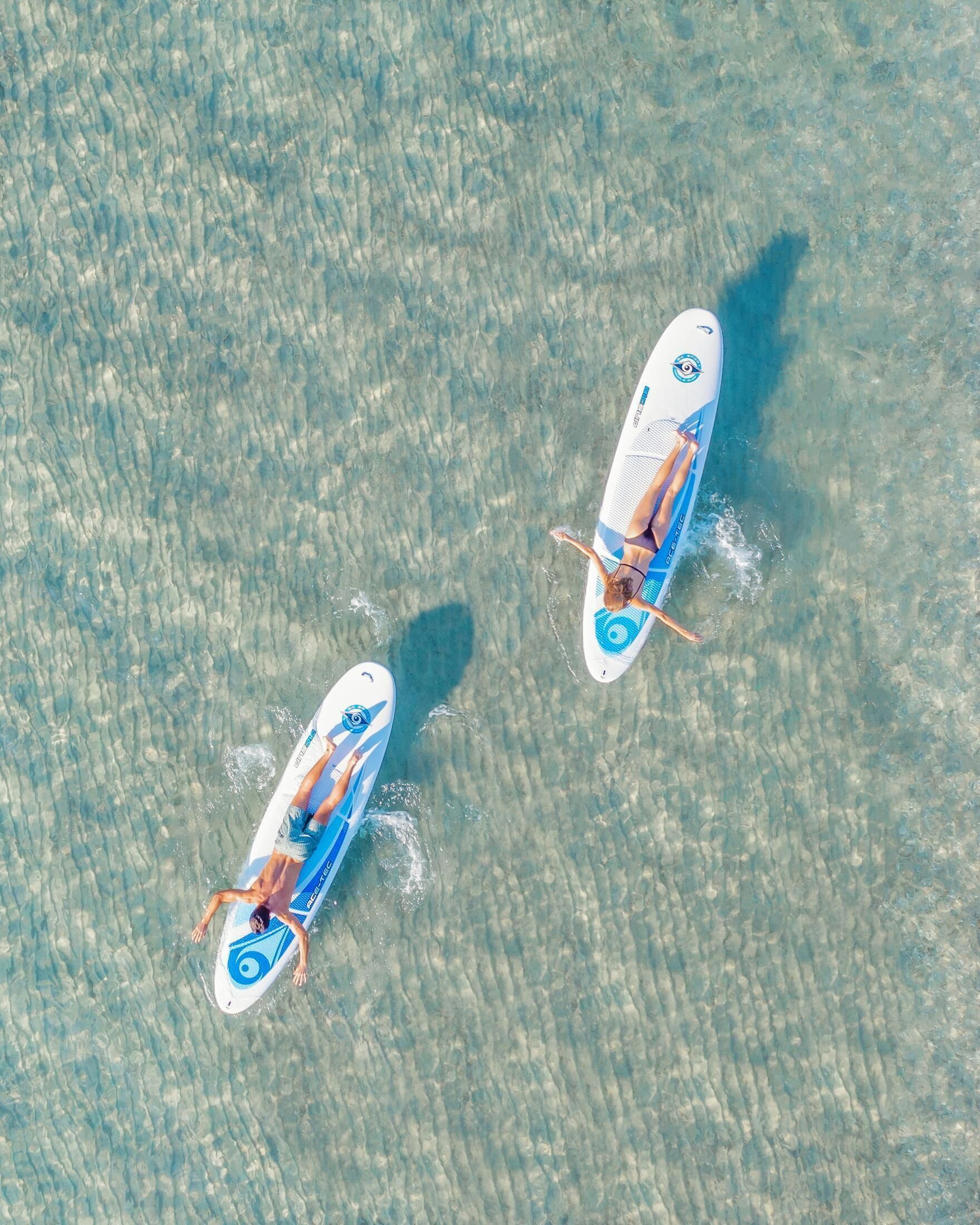 Dos tablas de remo sobre una superficie de agua clara.