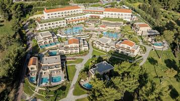 An aerial view of a resort with multiple buildings, swimming pools, and landscaped areas.