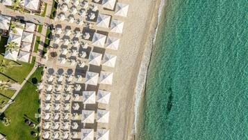 Una playa cerca, sillas reclinables de playa, sombrillas