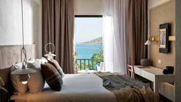 Un dormitorio con cama, lámparas de noche, un escritorio y vista al mar.