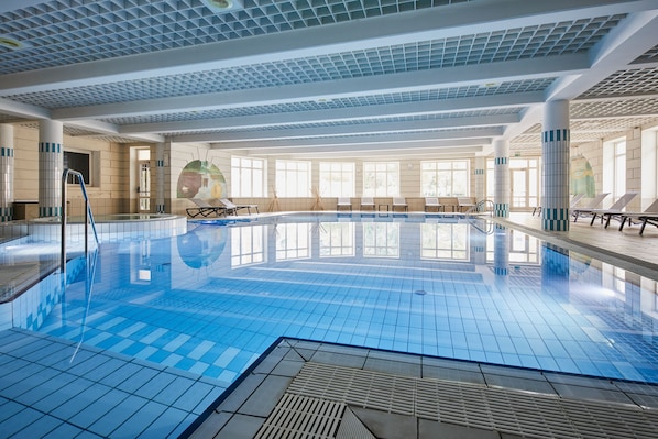 Una piscina cubierta, una piscina al aire libre de temporada, sombrillas