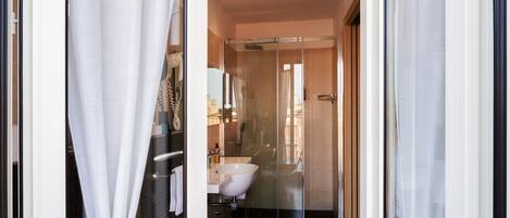A modern bathroom with a glass shower enclosure, a white sink, and a bathtub.