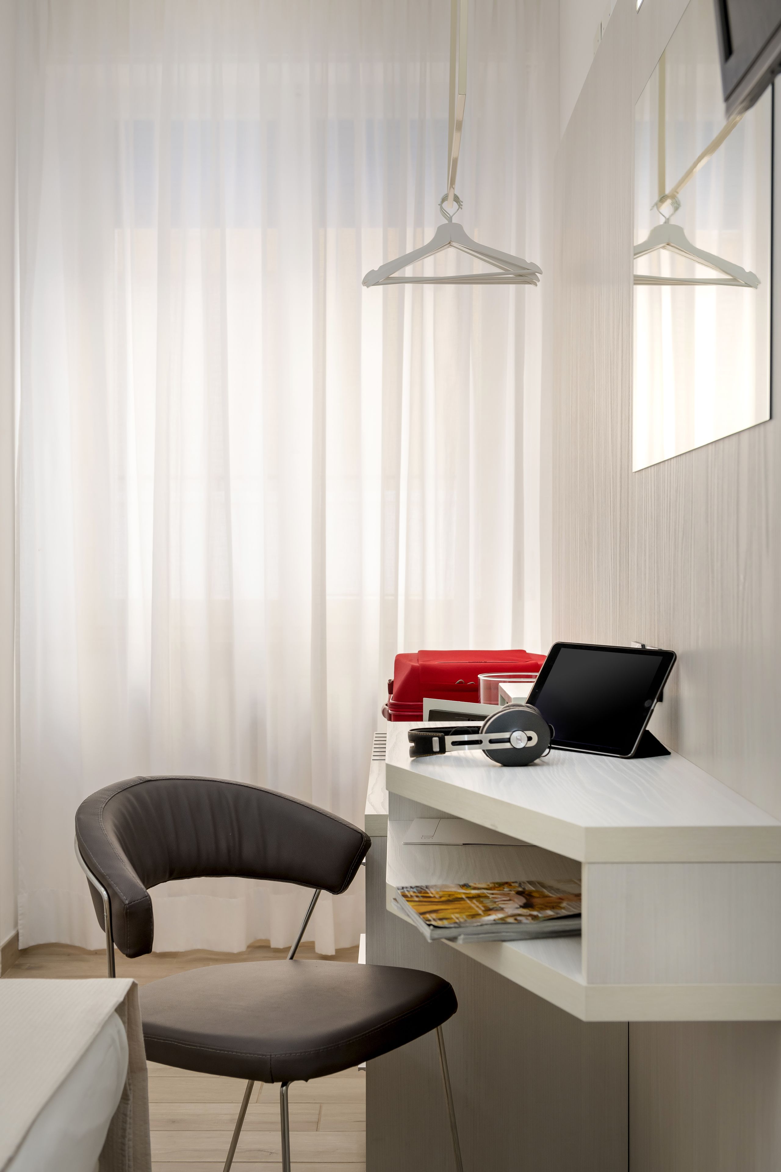 Une chambre moderne équipée d’un bureau, d’une chaise et d’un luminaire suspendu.
