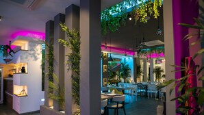 Un interior moderno con zona de comedor, jardines verticales e iluminación ambiental.