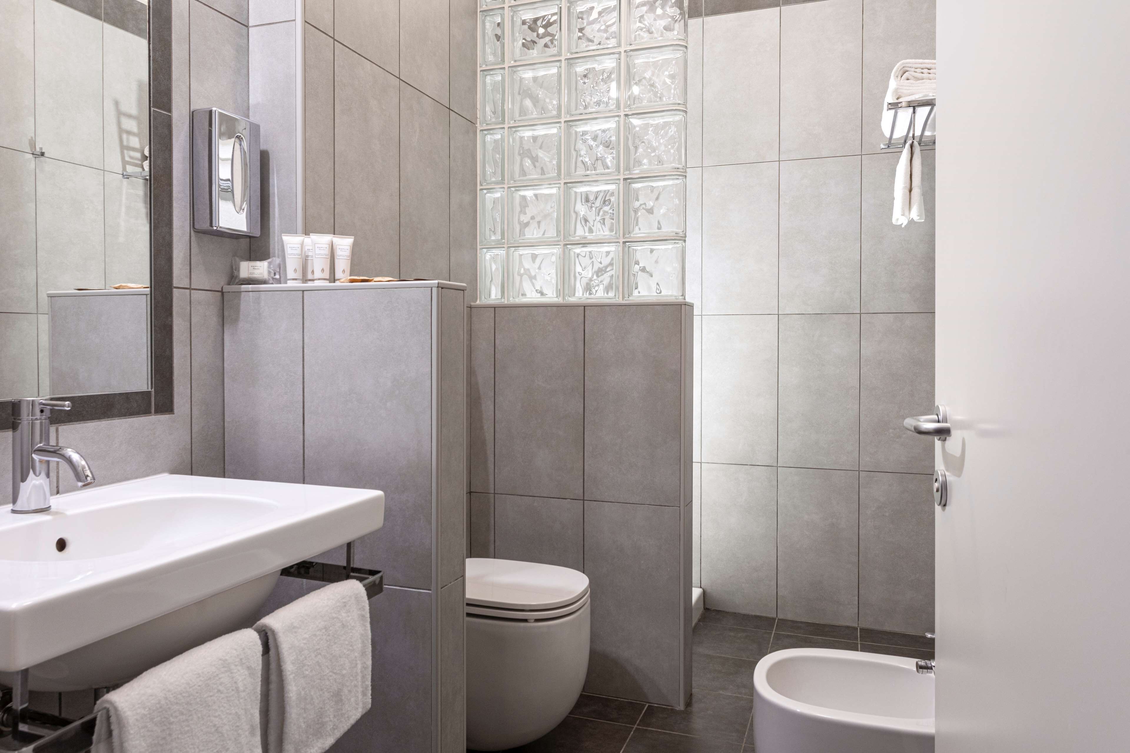 Un baño moderno con lavamanos, inodoro y bidé.