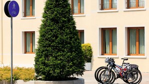 A building with multiple windows, a bicycle parked in front, and a sign indicating a pedestrian and bicycle path. - Best Western Titian Inn Hotel Treviso (Silea)