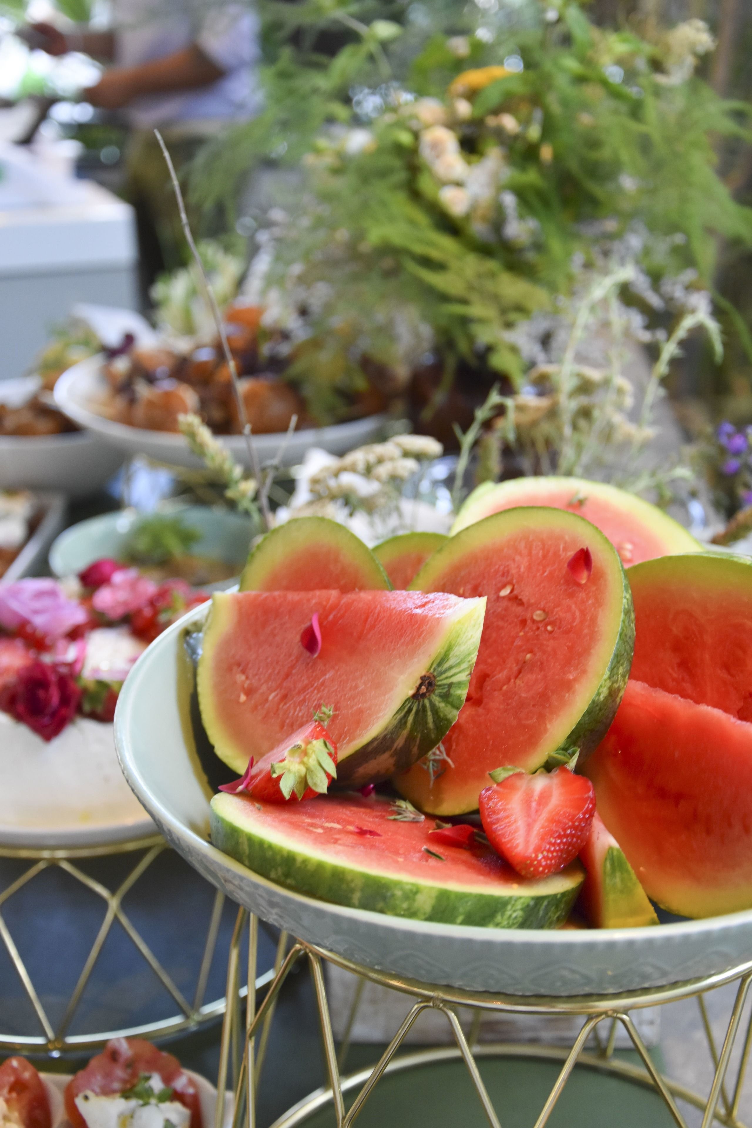 Un présentoir en métal avec des tranches de pastèque et des fraises.