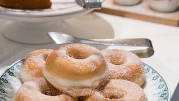 Ein Buffet mit verschiedenen Desserts, darunter ein Teller mit Donuts und eine Torte.