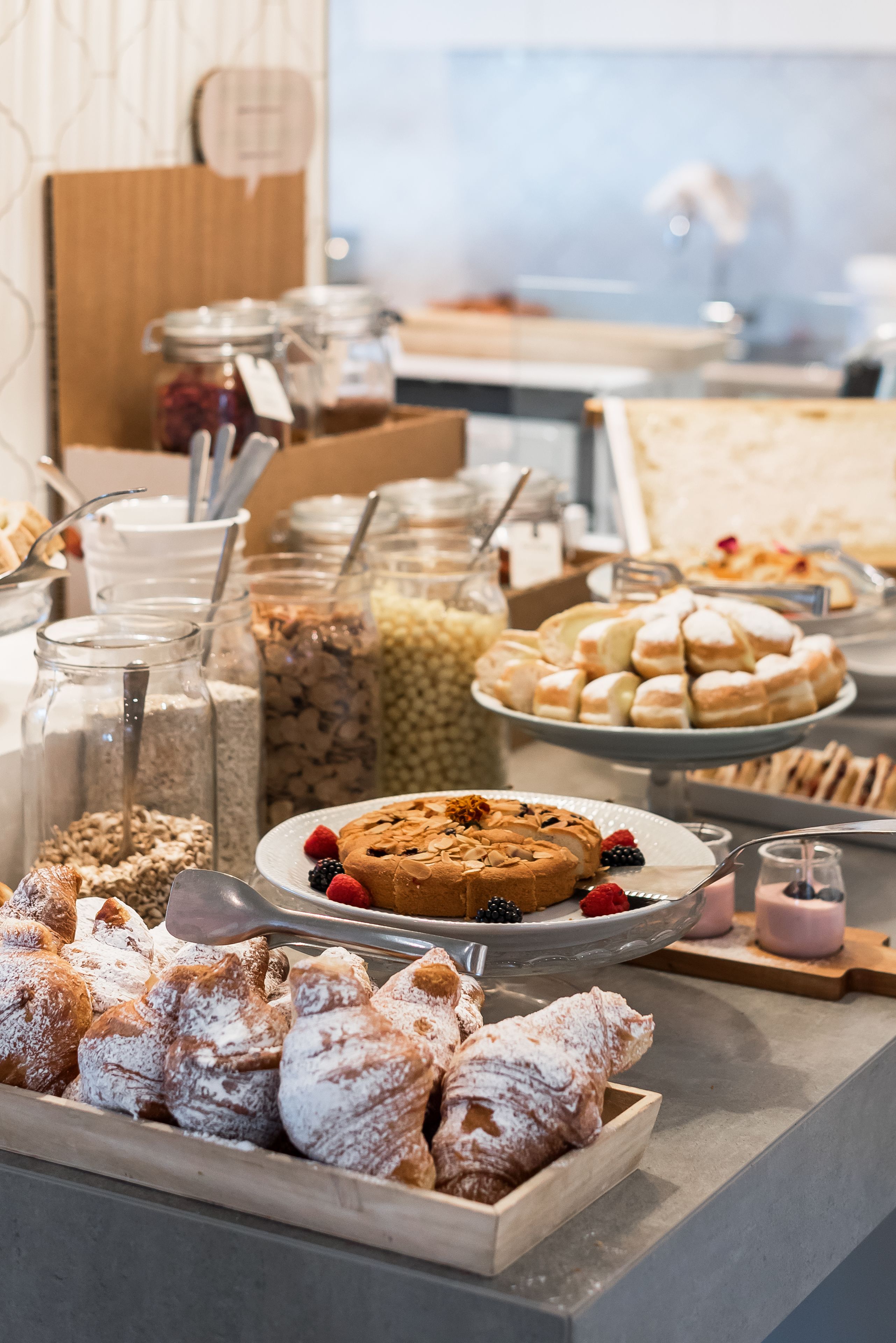 Ein reichhaltiges Buffet mit einer Auswahl an Speisen, darunter Gebäck, Früchten und Desserts.