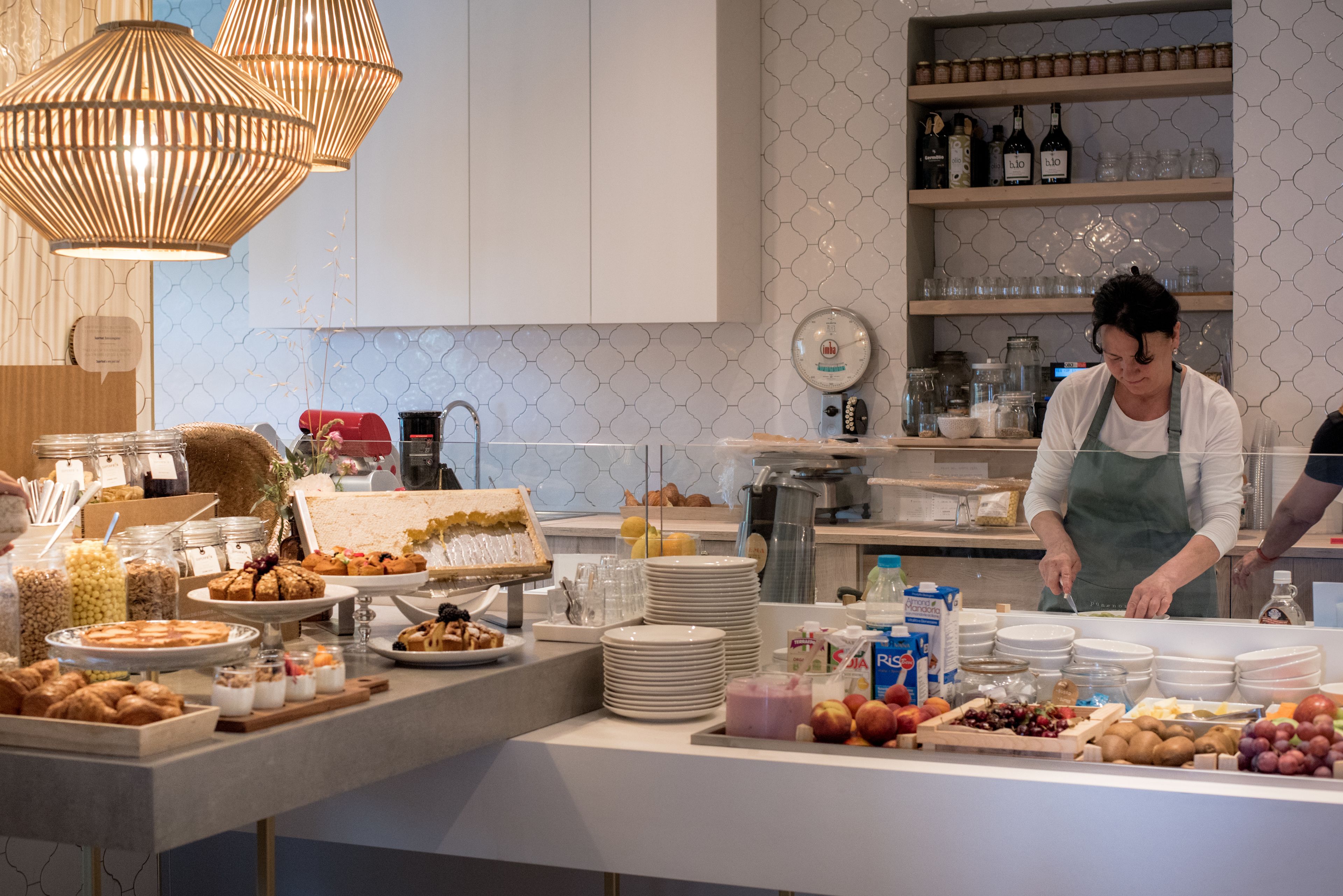 A breakfast buffet with various food items, a scale, and a clock on the wall.