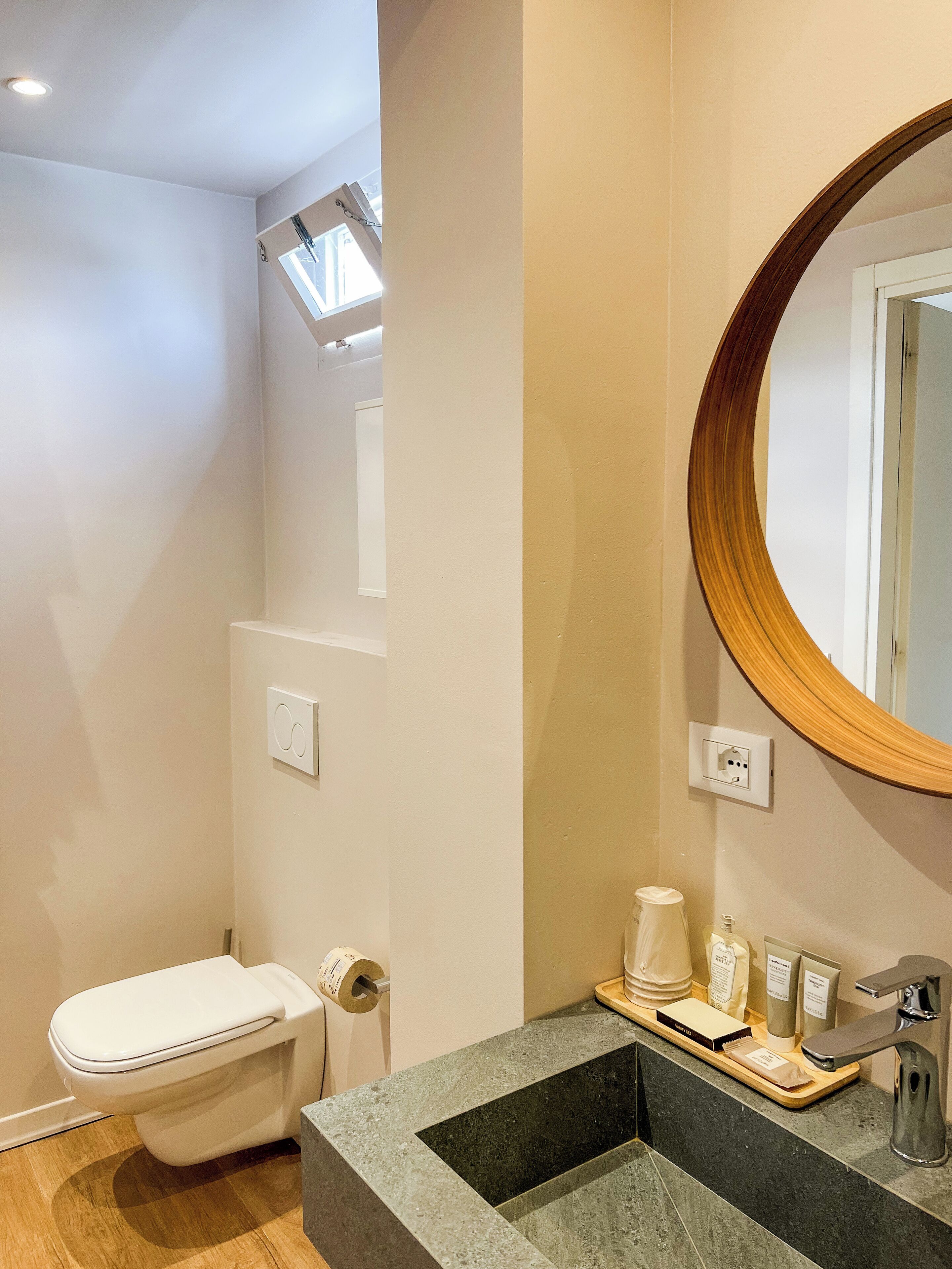 Une salle de bain moderne avec des toilettes, un lavabo et un miroir.