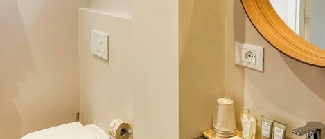 A modern bathroom with a toilet, sink, and mirror.